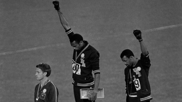 В 1968-м на Играх в Мехико два афроамериканца, Джон Карлос и Томми Смит, вышли получать медали без обуви, но в черных перчатках, и вскинули руки в салюте Black Power (власть черным).