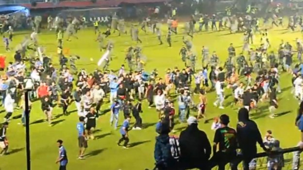 Болельщики убегают от полиции во время беспорядков на матче «Арема» — «Персебая».