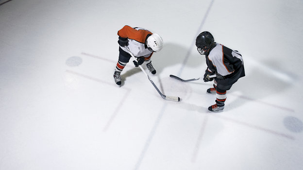 Два мальчика играют в хоккей на льду