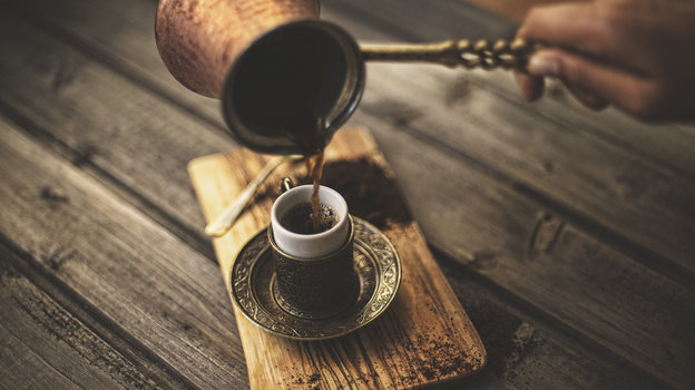 Турецкий кофе переливают из турки в чашку
