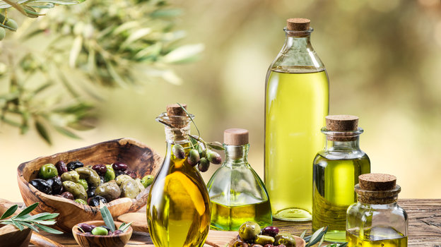 Оливковое масло в бутылках на светлом фоне