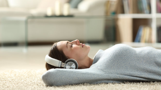 Девушка слушает музыку лежа на полу