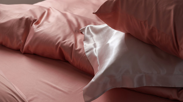 Вид на кровать крупным планом с красивым шелковым бельем
