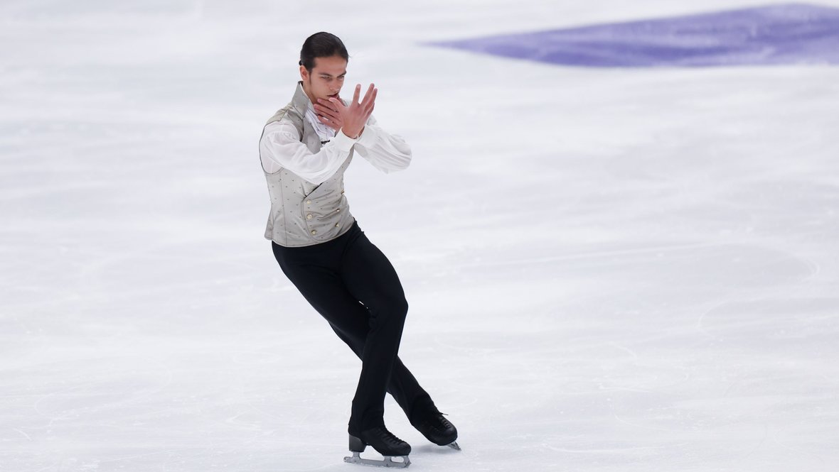 фигурист-мужчина выполняет вращение на льду